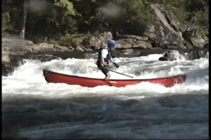 Milt Aitken Standing while surfing canoe