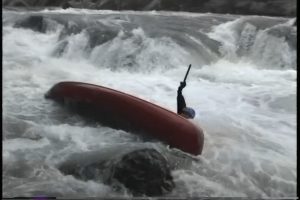 Milt Aitken swimming past Roadblock, broken paddle held high, Little River Canyon, AL